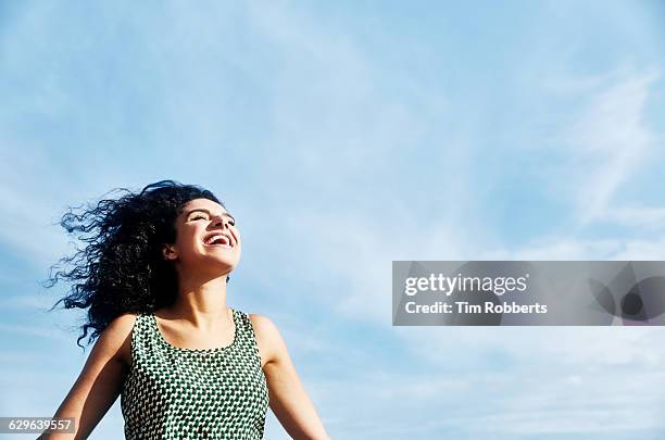 smiling woman with sky - camisa sin mangas fotografías e imágenes de stock