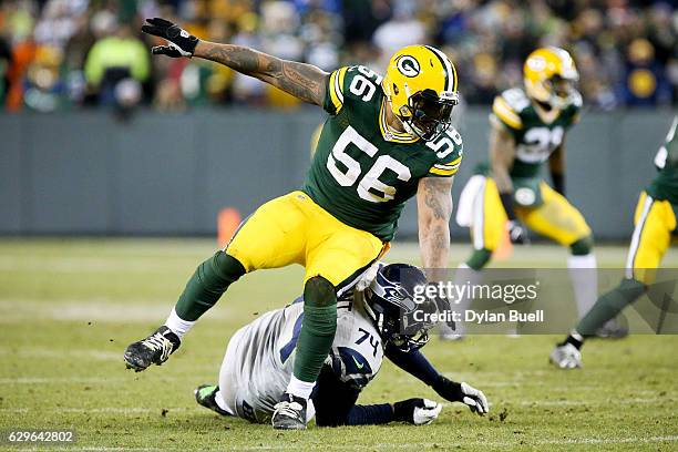 George Fant of the Seattle Seahawks blocks against Julius Peppers of the Green Bay Packers in the fourth quarter at Lambeau Field on December 11,...