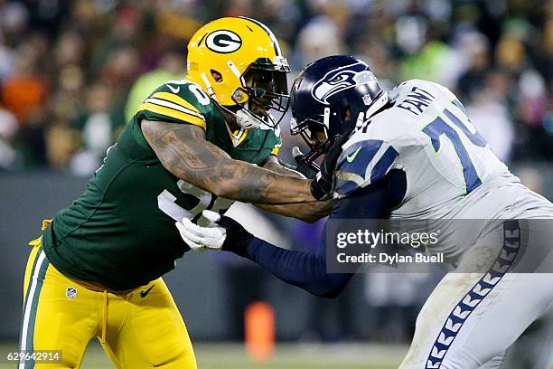 George Fant of the Seattle Seahawks blocks against Julius Peppers of the Green Bay Packers in the second quarter at Lambeau Field on December 11,...