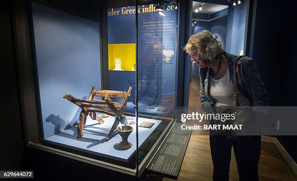 Picture taken on August 21, 2014 shows a visitor looking at artefacts on display during the exhibition 'Crimea: Gold and Secrets of the Black Sea' at...