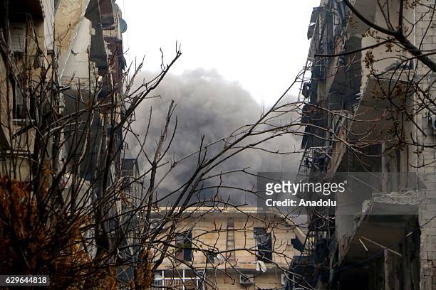 Smoke rises among damaged buildings after attacks of Assad forces, allied militias in al-Mashhad neighborhood of Aleppo, Syria on December 14, 2016.