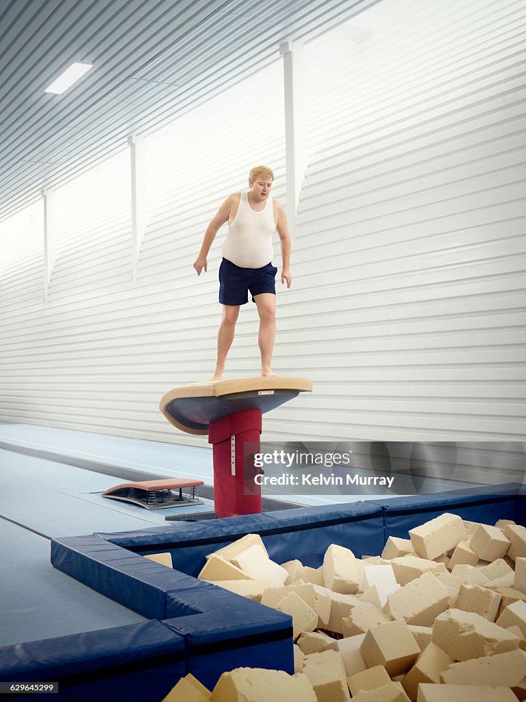 Man apprehensively looks in to foam pit in gym