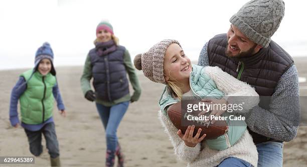 family playing on beach in winter - mid winter ball imagens e fotografias de stock