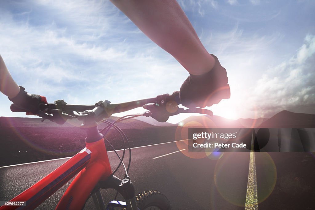 Handlebar view of cyclist on open road