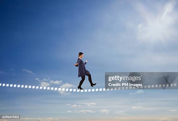 balancing on a digital tightrope - woman tightrope stock pictures, royalty-free photos & images