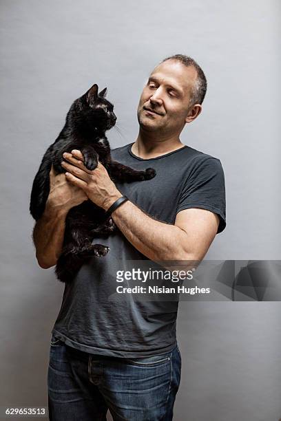 portrait of man with pet cat on gray background - cat studio stock pictures, royalty-free photos & images