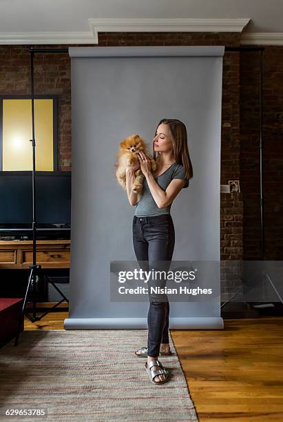 woman standing holding pet dog - spitz type dog stock pictures, royalty-free photos & images