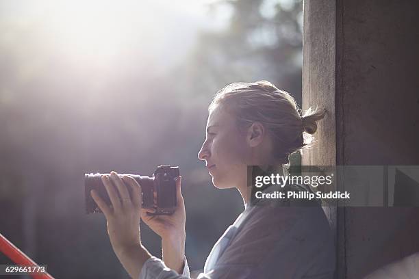 female photographer relaxing in hazy backlight - frauen mit fotoapparat stock-fotos und bilder