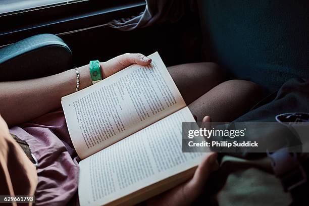 girl reading book on old train travelling