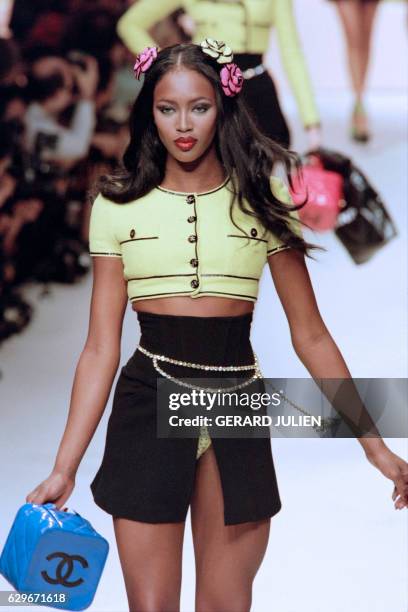 English model Naomi Campbell presents a new creation by French fashion house Chanel on October 17, 1994 as part of the Spring-Summer ready-to-wear...