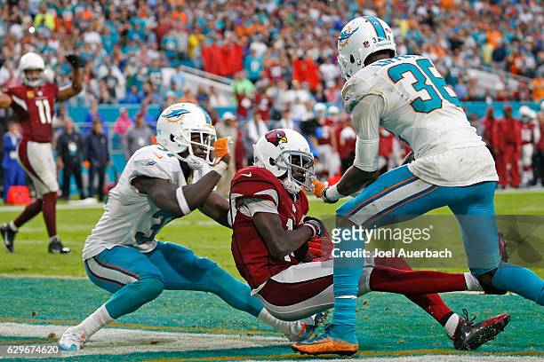 Nelson of the Arizona Cardinals catches a touchdown pass between Michael Thomas and Tony Lippett of the Miami Dolphins during fourth quarter action...