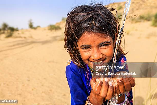 indische mädchen trinkt wasser, desert village, rajasthan, indien - asian water splash stock-fotos und bilder