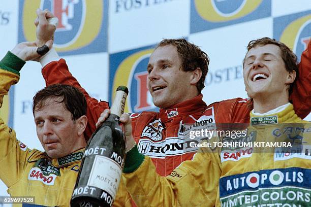 Austrian driver Gerhard Berger celebrates his victory with second place German driver Michael Schumacher and third place British driver Martin...