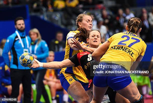 Germany's Kerstin Wohlbold vies with Sweden's Isabelle Gullden and Sabina Jacobsen during the Women's European Handball Championship Group I match...