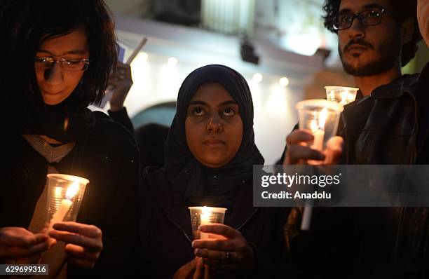 People hold candles during a commemoration for victims of a Sunday bombing at a Coptic cathedral in Cairo, Egypt on December 14, 2016. Twenty five...