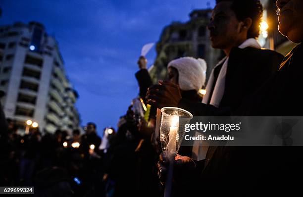 People hold candles during a commemoration for victims of a Sunday bombing at a Coptic cathedral in Cairo, Egypt on December 14, 2016. Twenty five...