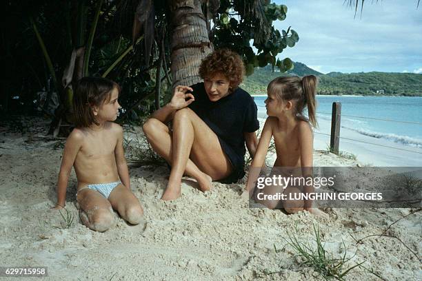 Marlene Jobert telling stories to her two twin daughters, Eva and Joy Green while on holiday. | Location: Saint Barthelemy Island, Guadeloupe, France.