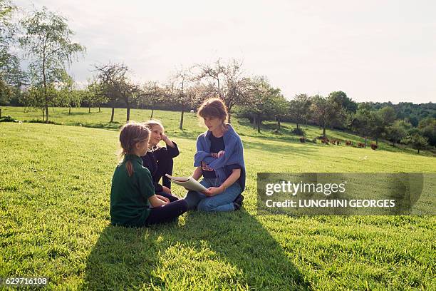 French singer and actress Elsa Lunghini reading stories to her twin cousins, Eva and Joy Green.