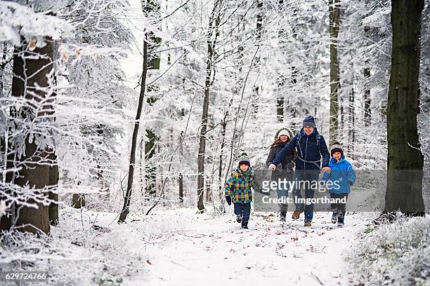 father with kids running in beautiful winter forest - winter stockfoto's en -beelden