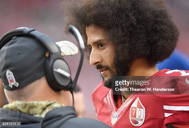 Colin Kaepernick of the San Francisco 49ers talks with head coach Chip Kelly on the sidelines during the fourth quarter of their NFL football game...