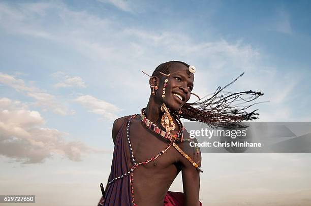 maasai warrior tribesman with braided hair flying - guerreros masai fotografías e imágenes de stock