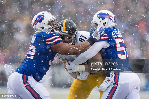 Jesse James of the Pittsburgh Steelers is tackled by Preston Brown and Lorenzo Alexander of the Buffalo Bills during the first quarter on December...