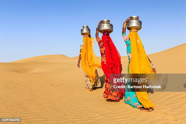 indische frauen tragen von wasser auf den kopf von lokalen gut - rajasthani women stock-fotos und bilder
