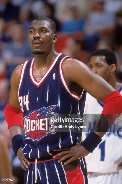 Hakeem Olajuwon of the Houston Rockets stands on the court during the game against the Orlando Magic at the Compaq Center in Houston, Texas. The...