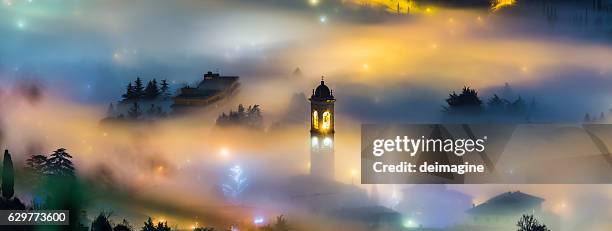 foggy landscape over a country with bell tower - milan night stock pictures, royalty-free photos & images