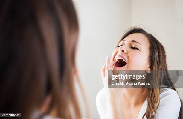 taking care of her skin and teeth - tandpijn stockfoto's en -beelden