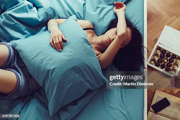 sick woman sleeping at home - hangover stockfoto's en -beelden