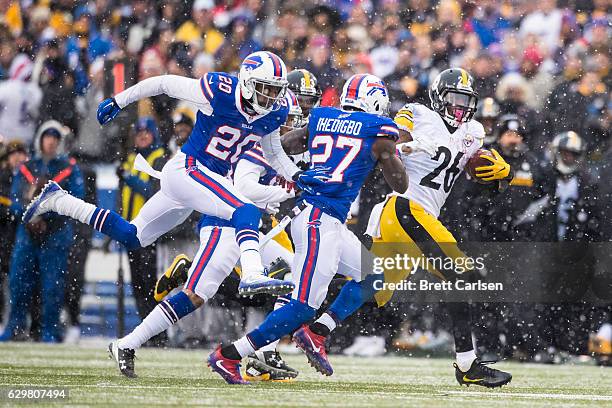 Le'Veon Bell of the Pittsburgh Steelers carries the ball as Corey Graham and James Ihedigbo of the Buffalo Bills pursue during the game on December...