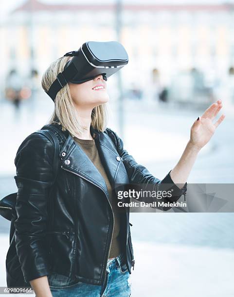 women testing virtual reality simulator on the street - virtual reality headset stockfoto's en -beelden