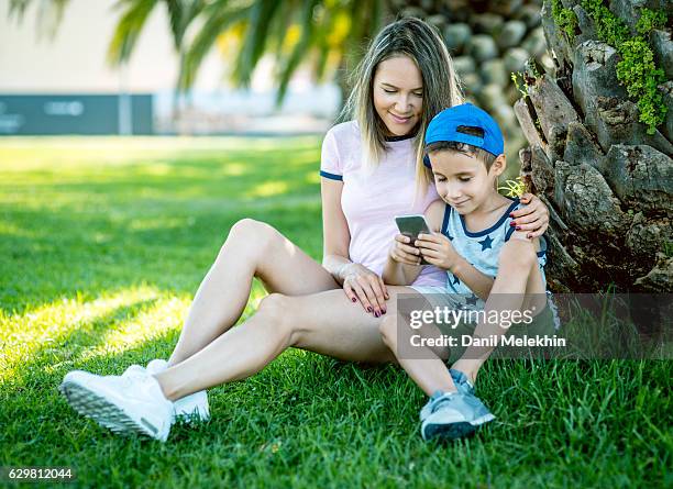 sohn und mutter er ein smartphone benutzt - parental control stock-fotos und bilder