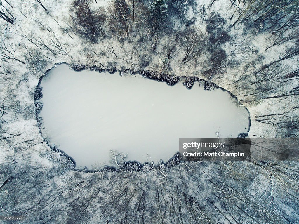 Aerial of frozen pond with first ice during Winter