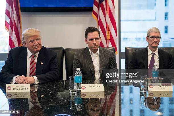 President-elect Donald Trump, Peter Thiel and Tim Cook, chief executive officer of Apple, Inc., listen during a meeting with technology executives at...