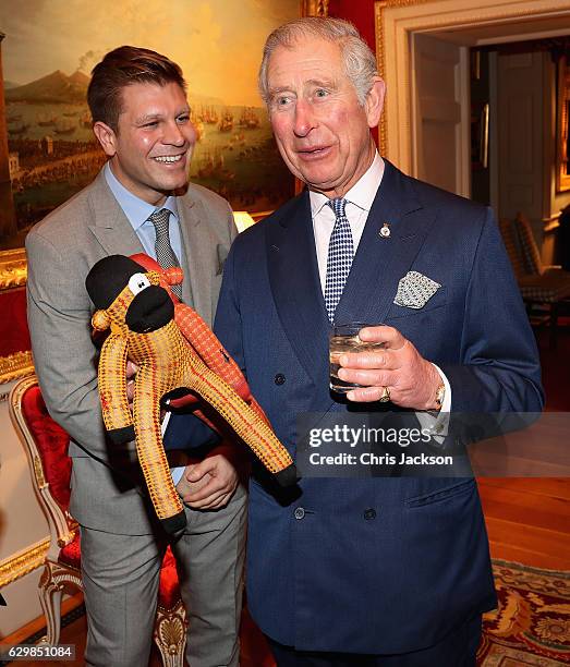 Prince Charles, Prince of Walesis presented with two sock monkeys by Ryan Palmer of the London Sock Co for Prince George and Princess Charlotte by at...