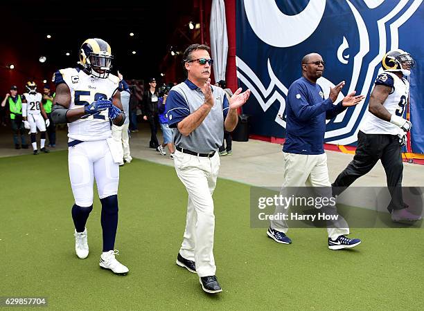Head coach Jeff Fisher of the Los Angeles Rams comes on to the field with Alec Ogletree before the game against the Atlanta Falcons at Los Angeles...