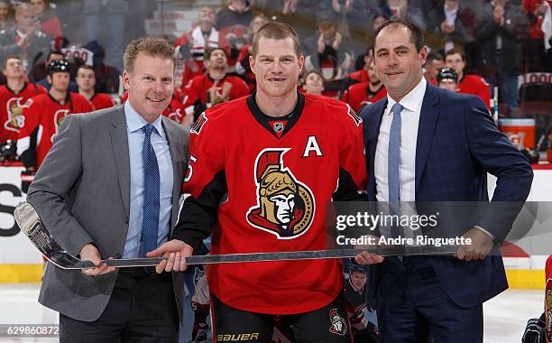 Former teammates Daniel Alfrdedsson and Chris Phillips present Chris Neil of the Ottawa Senators with a silver stick in a pre-game ceremony for...