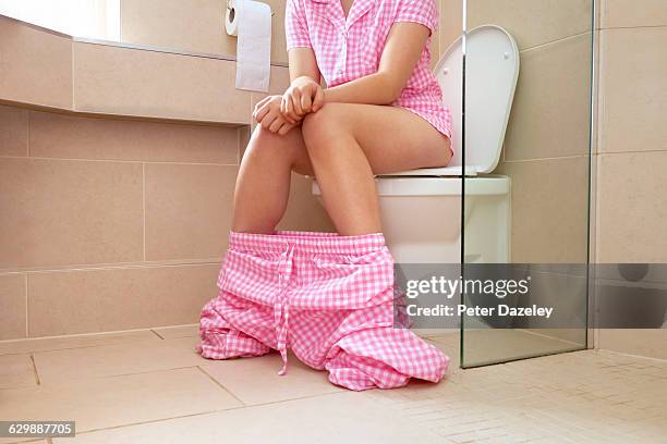 teenager sitting on the toilet - toilet bowl bathroom stock pictures, royalty-free photos & images