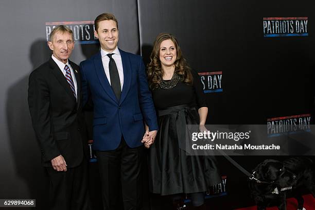 Boston Police Commissioner Billy Evans poses with Boston Marathon survivors Patrick and Jessica Downes and dog Rescue on the red carpet at the...