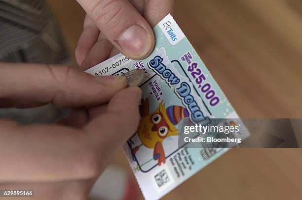 Tatts Group Ltd. Instant Scratch-It scratchcard is arranged for a photograph at a newsagent's store in Melbourne, Australia, on Thursday, Dec. 15,...