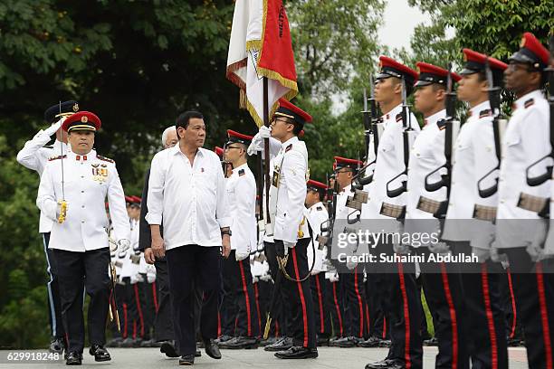 Philippine President Rodrigo Duterte inspects the guard of honour, accompanied by Singapore President, Tony Tan Keng Yam at the Istana during the...