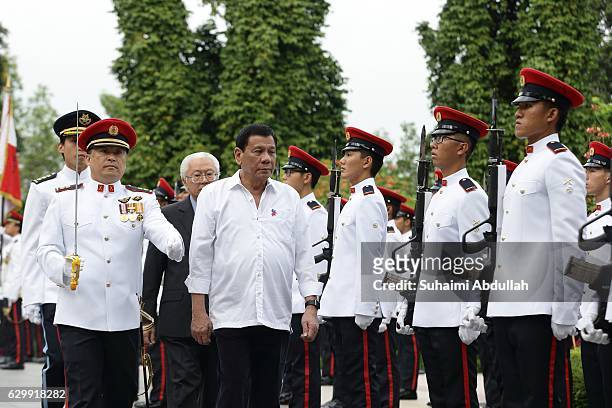 Philippine President Rodrigo Duterte inspects the guard of honour, accompanied by Singapore President, Tony Tan Keng Yam at the Istana during the...