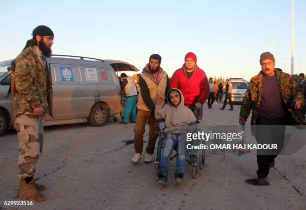 Wounded Syrian, who was evacuated from rebel-held neighbourhoods in the embattled city of Aleppo, is helped by aid workers upon his arrival in the...