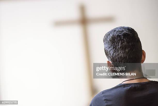 An Iranian refugee visits a course preparing him to convert into christian confession by baptism in Berlin, on October 23, 2016. / AFP / CLEMENS BILAN