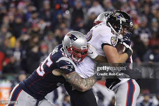 Chris Long of the New England Patriots tackles Dennis Pitta of the Baltimore Ravens during their game at Gillette Stadium on December 12, 2016 in...