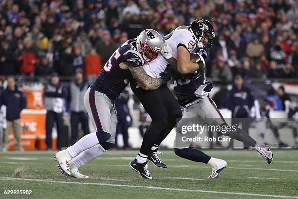 Chris Long of the New England Patriots tackles Dennis Pitta of the Baltimore Ravens during their game at Gillette Stadium on December 12, 2016 in...