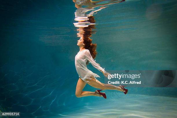 portrait of a female model in high heels underwater in a swimming pool in san diego, california. - kids swimsuit models stockfoto's en -beelden