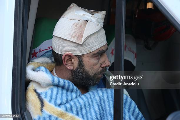 Wounded civilians arrive for a convoy, including buses and ambulances, wait at a crossing point at Amiriyah District of Aleppo Syria on December 15,...